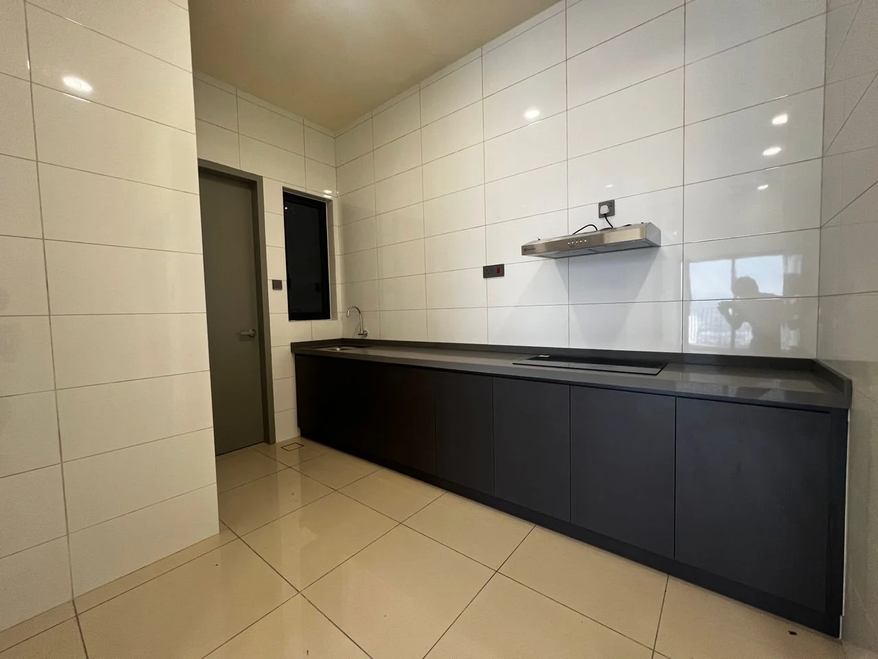 Kitchen features: white glossy tile walls, black cabinetry, grey countertop, single-bowl stainless-steel sink, chrome pull-down faucet, built-in range hood, ceramic tile flooring, recessed downlights; style: modern.